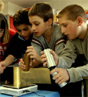 Boys weighing cylinders on scale